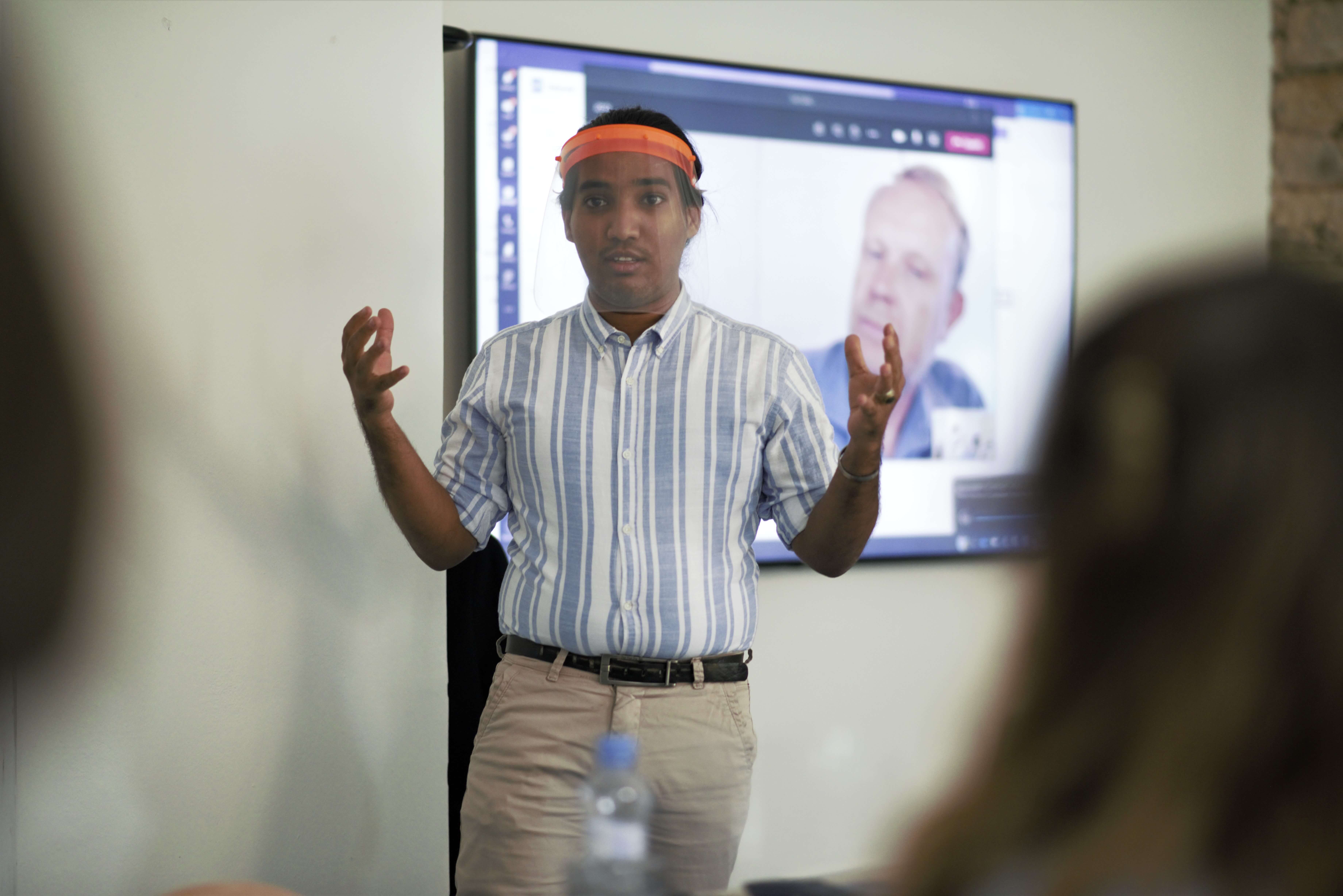 Student Ahmed Salem při řečnickém cvičení, v pozadí na obrazovce ho sleduje kouč Martin Vasquez